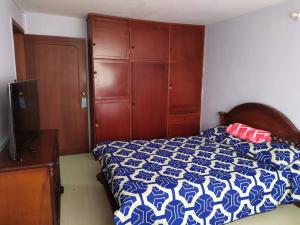 帕斯托Hermoso apartamento en Pasto. Central parque San Andrés的卧室配有蓝色和白色的床和梳妆台。