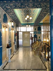 斋浦尔四季民宿的走廊设有蓝色的墙壁和天花板及椅子