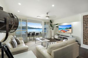 汉密尔顿岛Frangipani Beachfront Lodge 202 on Hamilton Island by HamoRent的带沙发和电视的客厅