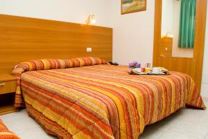 阿里恰加利福尼亚酒店的一间卧室配有一张大床和木制床头板