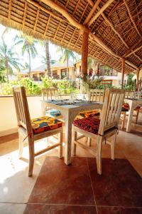 米查维Sansi Kae Beach Resort的配有桌椅的客房内的餐桌和椅子