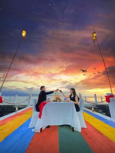 美娜多NDC Resort & Spa的坐在船上桌子上的男女