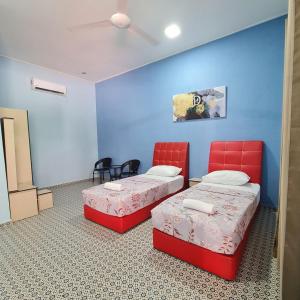 Kampung RajaD'EMBUN INAP DESA BESUT的配有蓝色墙壁和红色椅子的客房内的两张床