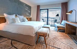 蒂涅Hôtel VoulezVous by Les Etincelles的酒店客房设有一张大床和一个阳台。