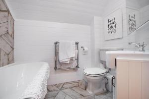 赛伦塞斯特Luxury lodge in the heart of the Cotswolds的白色的浴室设有浴缸、卫生间和水槽。
