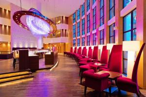 布克维比克维尔丽笙布鲁度假酒店的一间设有红色椅子的餐厅和一间酒吧