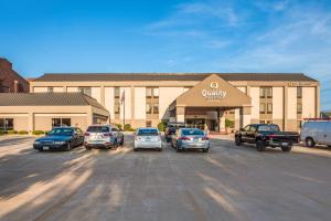 昆西Quality Inn & Suites Quincy - Downtown的停车场,停车场停在大楼前