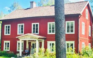 Garpenberg5 bed country home only 2 hrs north of Stockholm的一座红色的房子,前面有两个人