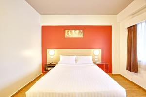 合艾Red Planet Hat Yai SHA extra plus的卧室配有红色墙壁上的白色床