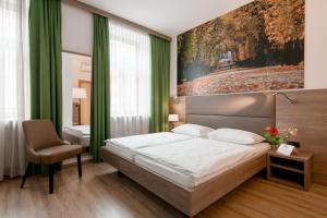 维也纳露西亚酒店的卧室配有一张床,墙上挂有绘画作品
