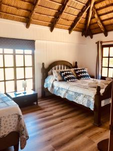 何塞伊格纳西奥Malta Homestay的一间卧室设有两张床和木制天花板