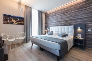 都灵和谐酒店的一间卧室设有一张带木墙的大床