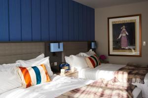 特灵盆德雷庄园酒店的酒店客房设有两张床和蓝色的墙壁。