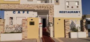 泰塔温Hotel al rayan的带有咖啡馆和标志的建筑的 ⁇ 染