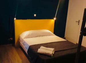 巴黎布鲁塞尔酒店的小卧室配有一张带黄色床头板的床