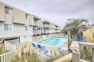 海洋岛海滩Cozy Ocean Isle Beach Condo, Steps to the Beach!的阳台设有游泳池、椅子和公寓