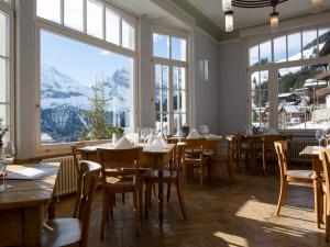 米伦雷吉纳酒店的餐厅设有桌椅和大窗户。