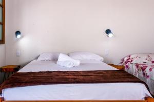 韦尔卡鲍Chalé aconchegante com Wi-Fi no Vale do Capão - BA的一张床上有两个枕头的房间