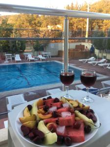 帕莫卡莱Mucize Termal Spa的桌上一盘水果和两杯葡萄酒