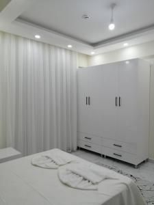 代姆雷Deniz Apart的白色卧室配有床和衣柜