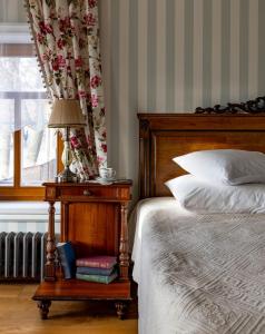 苏兹达尔Бутик-отель Пестово подворье的一间卧室配有一张带台灯的桌子的床