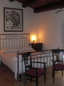 切法卢切法卢乡村旅行酒店的一间卧室配有一张床、两把椅子和一张桌子