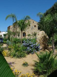 切法卢切法卢乡村旅行酒店的花园中一座花卉的古老石头建筑