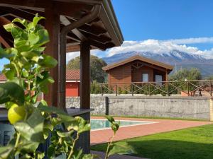 Aci SantʼAntonioAgricampeggio Verde Etna的一座带网球场和山脉的房子