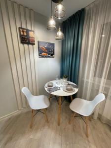 巴甫洛达尔Krivenko 49 Str by Slissenko Inn的一间配备有白色桌子和两把椅子的用餐室