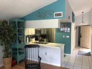 帕姆港Florida Condos on Lake Tarpon的厨房拥有蓝色和白色的墙壁,配有椅子