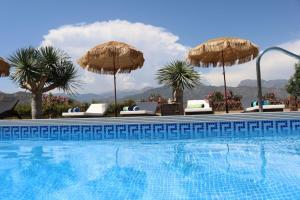托罗克斯Exceptional Costa del Sol villa for 8, Hi spec, Tranquil setting, Amazing views. Heated pool.的游泳池旁配有遮阳伞和椅子