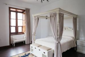 比拉夫洛尔La Casa Inglesa Vilaflor的白色卧室设有天蓬床和窗户