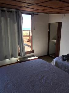 凯博波洛尼奥Carmela Cabo Polonio的一间卧室设有一张床和一个大窗户