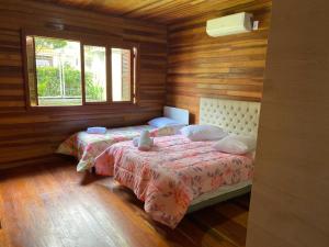 卡内拉Chale Morada da Serra的一间卧室设有两张床和两个窗户。