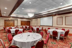 朴茨茅斯朴茨茅斯贝斯特韦斯特优质酒店的一间会议室,配有白色的桌子和红色的椅子