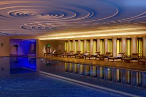 重庆重庆丽笙世嘉酒店的酒店大堂的游泳池,设有椅子和天花板