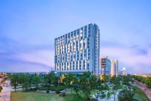 上海上海宝龙丽笙酒店的一座高大的蓝色建筑,前面有树木