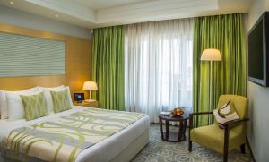 艾哈迈达巴德Radisson Blu Hotel Ahmedabad的酒店的客房 - 带一张床、椅子和窗户