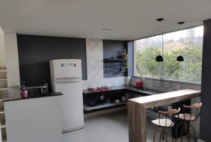 新利马Loft Espaço Vila da Serra的厨房配有白色冰箱和窗户。
