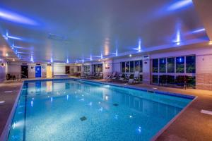 格兰瑟姆The Barn Hotel & Spa, Sure Hotel Collection by Best Western的大楼内带蓝色灯光的大型游泳池