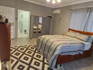 弗里敦Marie & Sons Property的一间卧室设有床、窗户和地毯。