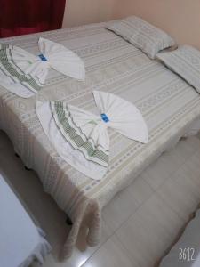 托坎廷斯州圣费利克斯POUSADA ROTA DAS ÁGUAS的两张白色的床,上面有遮阳伞