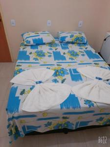 托坎廷斯州圣费利克斯POUSADA ROTA DAS ÁGUAS的一张带蓝色和白色棉被和枕头的床