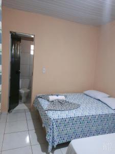 托坎廷斯州圣费利克斯POUSADA ROTA DAS ÁGUAS的一间带两张床的卧室和一间带卫生间的浴室