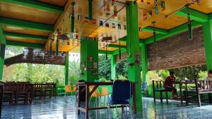 Tangkahan唐卡汉绿色森林酒店的餐厅拥有绿色和黄色的墙壁和桌子