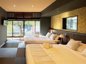 廿日市KIYOMORI的酒店客房设有三张床和窗户。
