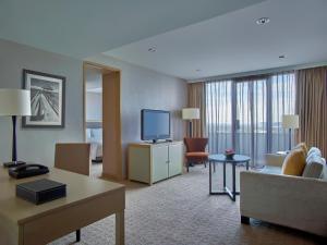 马尼拉马尼拉新世界酒店的一间配备有沙发及电视的酒店客房
