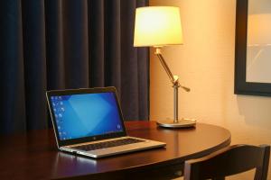 冈山冈山ANA皇冠假日酒店的一张带台灯的桌子上的笔记本电脑