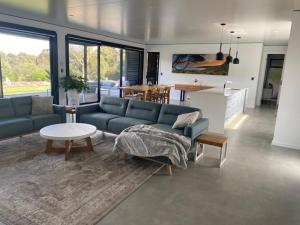 亚林加普Seaview - spa and ocean views in luxury的客厅配有蓝色的沙发和桌子
