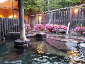 雫石町夜莺日式旅馆的后院的池塘,花卉和围栏